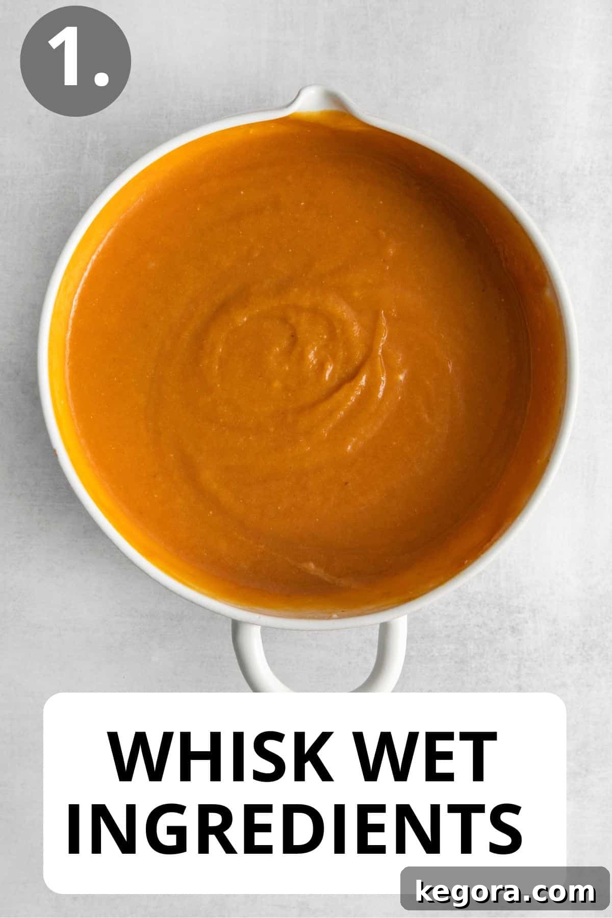 A large white bowl filled with wet ingredients for crustless pumpkin pie, perfectly mixed and ready for the next step.