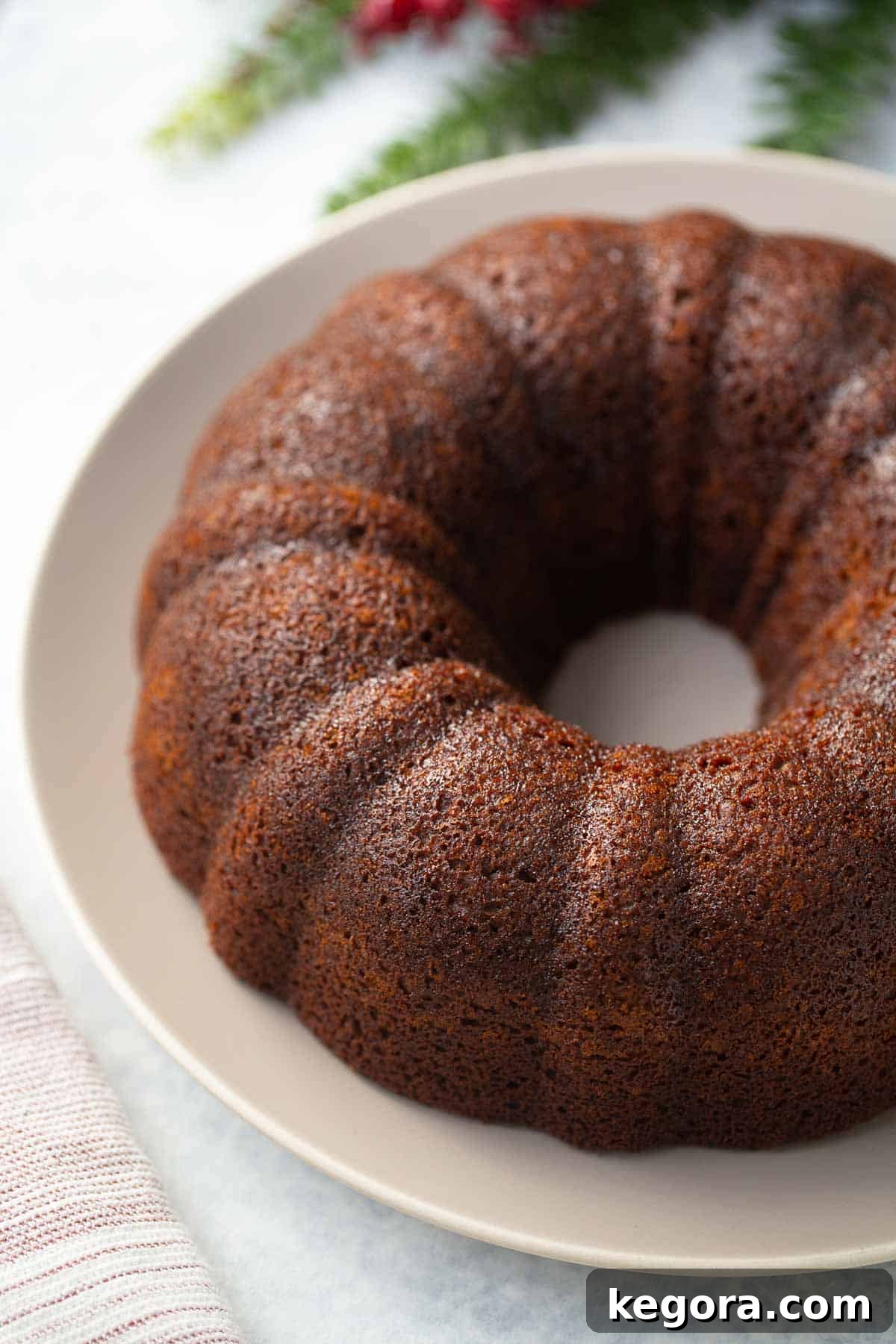 Gluten-Free Gingerbread Cake A slice of moist gluten-free gingerbread cake on a white plate, ready to be enjoyed.