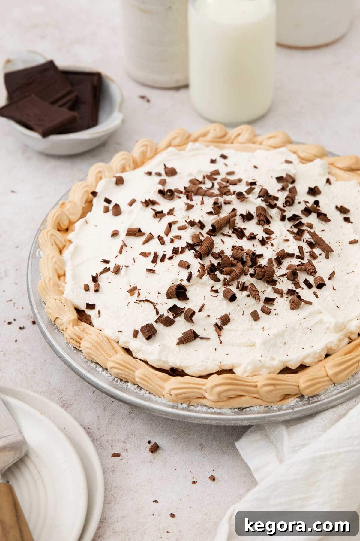 An inviting overhead view of a beautifully prepared Chocolate Angel Pie on a clean countertop, with a glass of milk subtly blurred in the background, highlighting the pie's elegance.