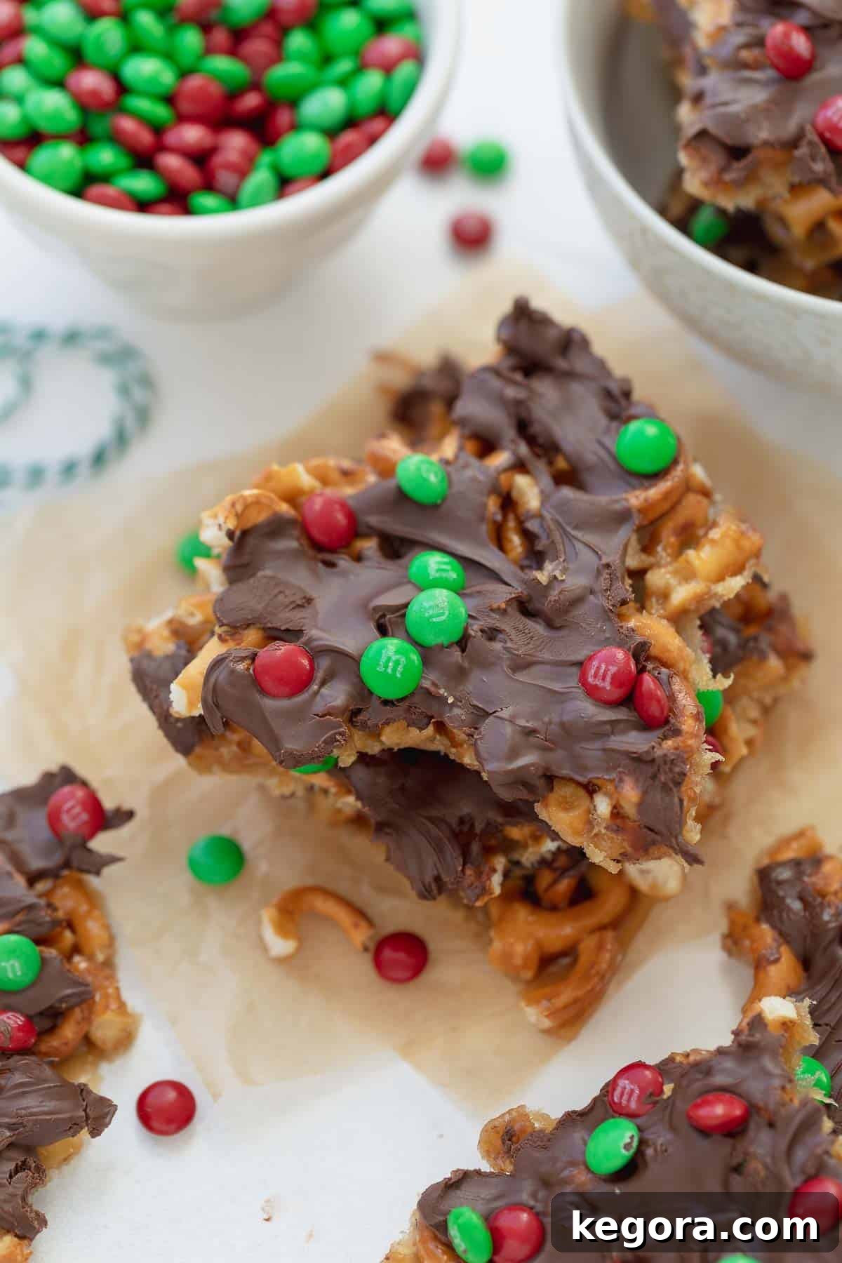 Festive Gluten-Free Pretzel Delights 2 Festive gluten-free Christmas pretzel treats with M&M's on parchment paper