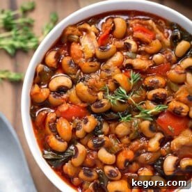 Southern Style Instant Pot Black-Eyed Peas 4 Black-Eyed Peas in a white bowl next to spoon on wooden board