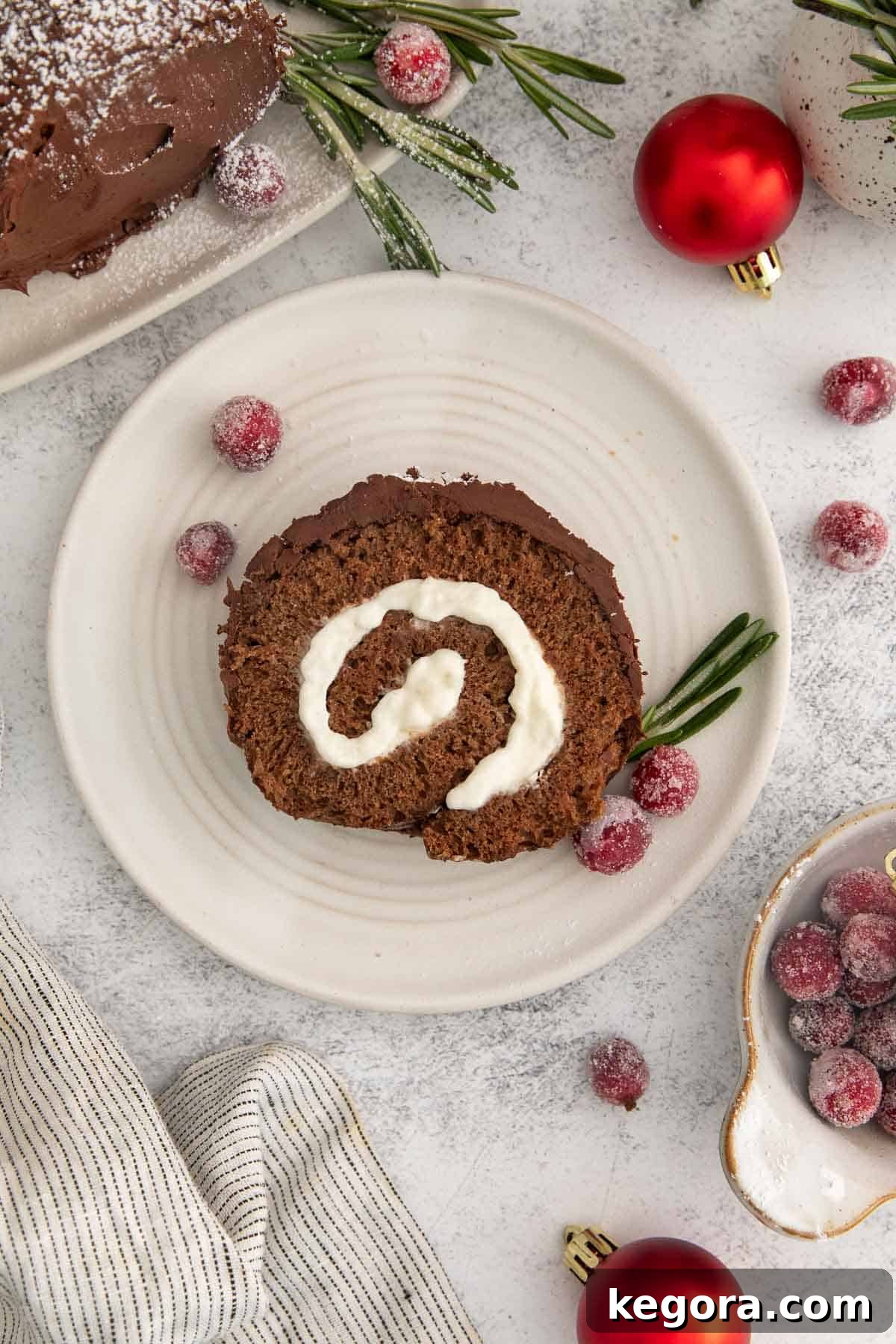 Gluten-Free Holiday Log Delight 14 An overhead view of a perfectly sliced gluten-free chocolate yule log on a white plate, revealing its layers of cake and filling.
