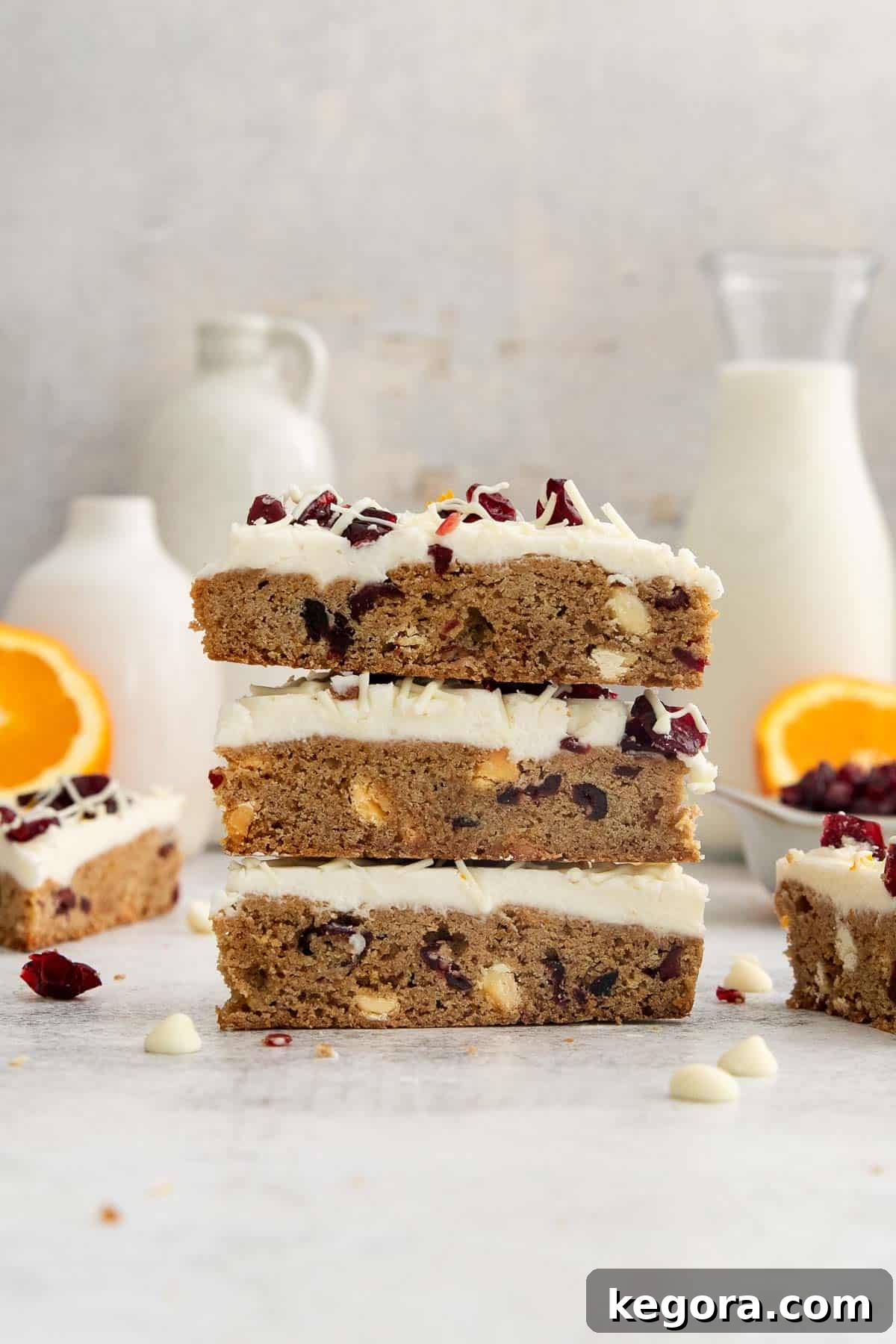 Your Gluten-Free Starbucks Bliss Fix 3 A stack of three perfectly frosted gluten-free Starbucks bliss bars with dried cranberries and white chocolate drizzle on a countertop.
