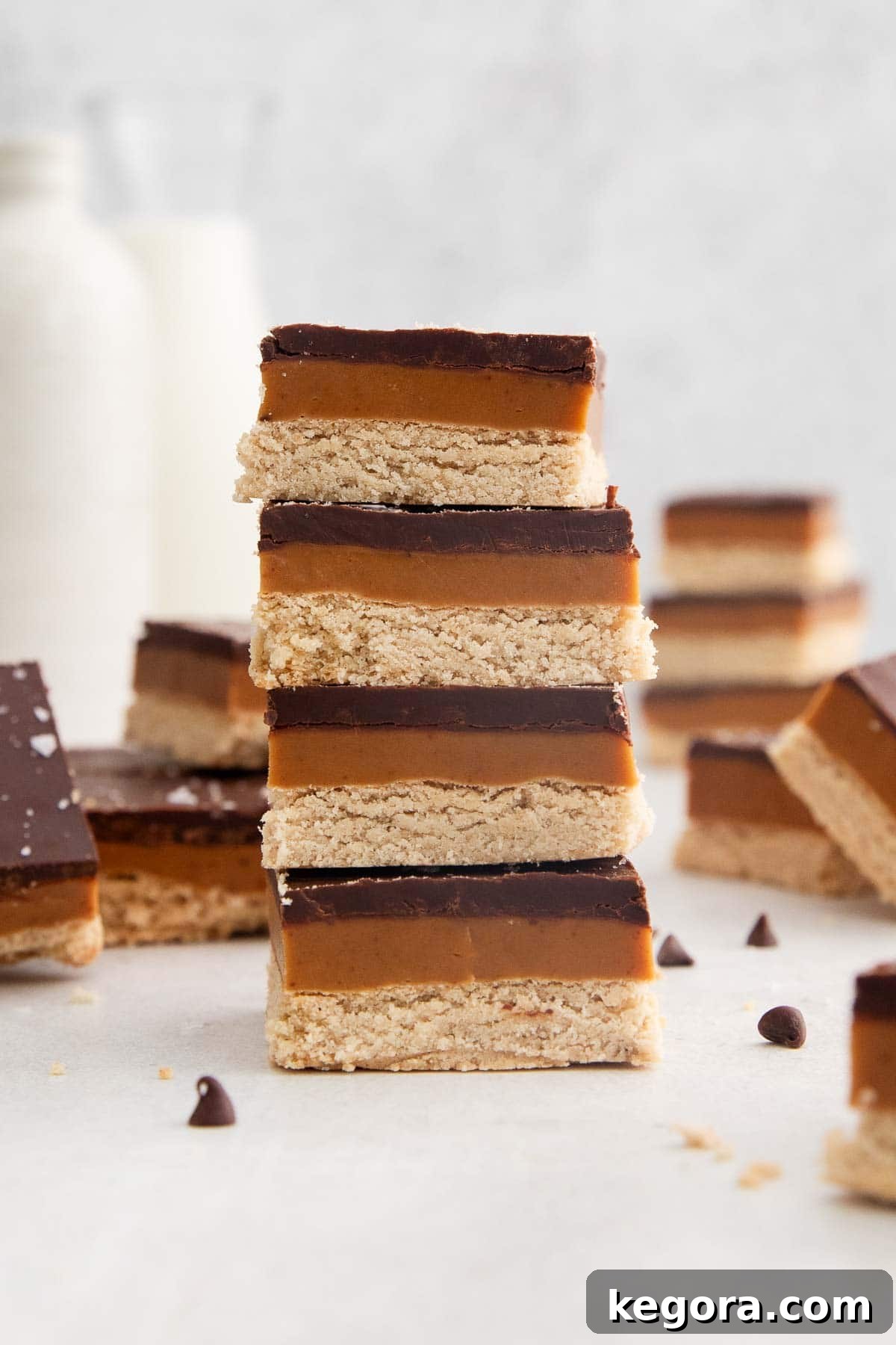 Stacked pieces of gluten-free millionaire's shortbread on a countertop, ready to be enjoyed.
