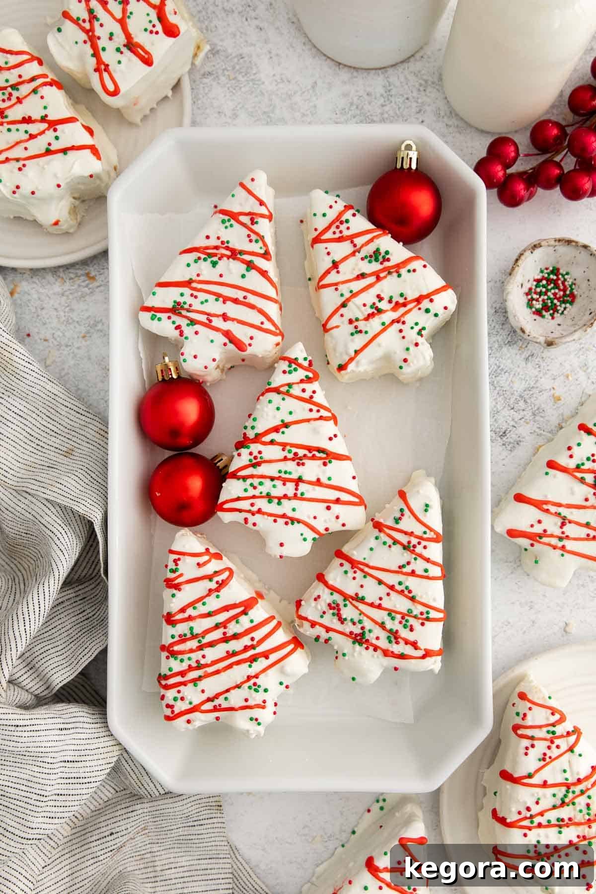 gluten-free little debbie christmas trees in baking dish with red ornaments, a festive holiday scene.