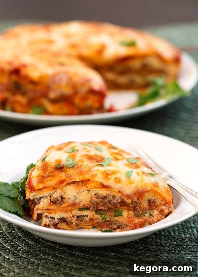 Lasagna slice on a white plate with silver fork
