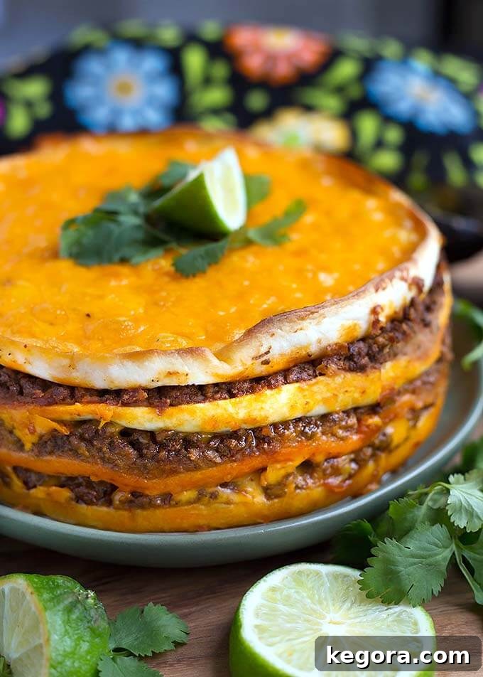 Instant Pot Taco Pie on a green plate with a lime wedge on top, garnished with cilantro