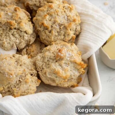 Gluten-free drop biscuits on a tea towel in a white baking dish, ready to be served.