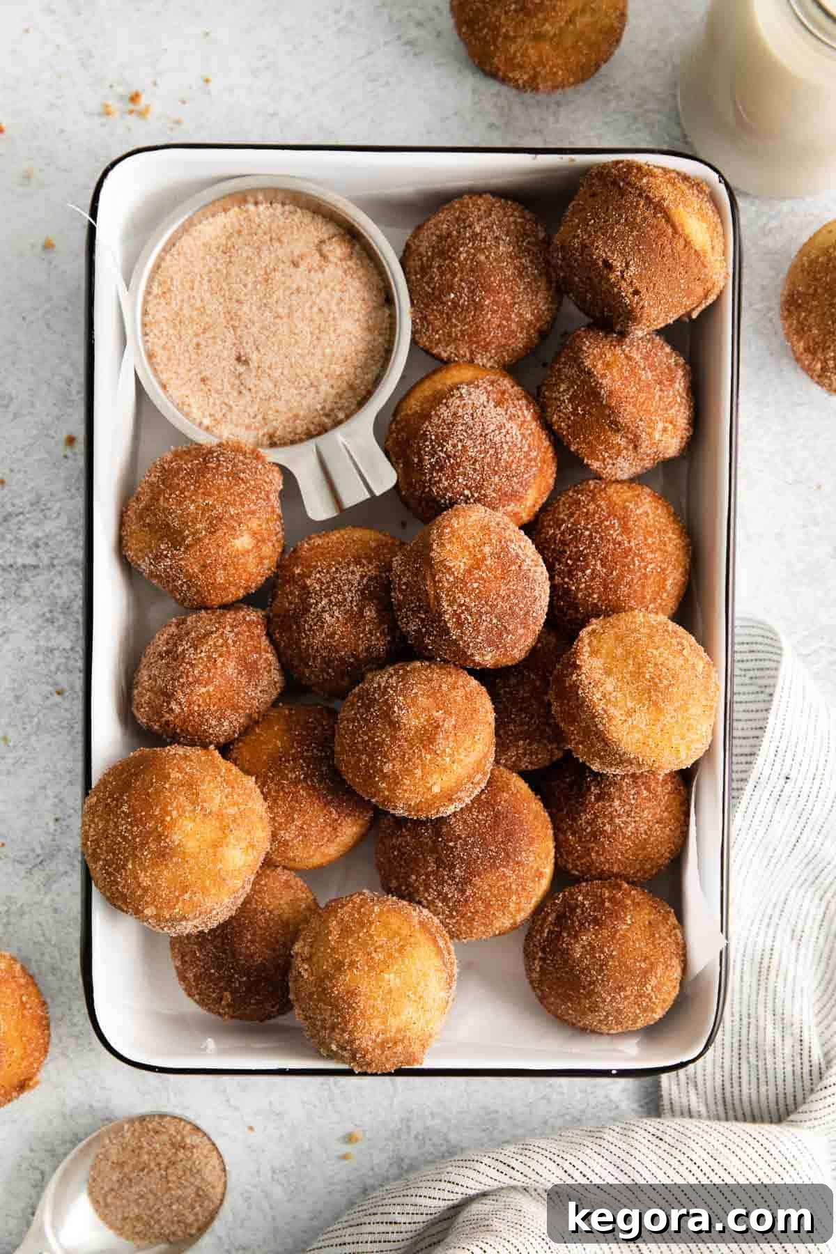 A far out view of French breakfast puffs in a casserole dish, glistening with cinnamon sugar.