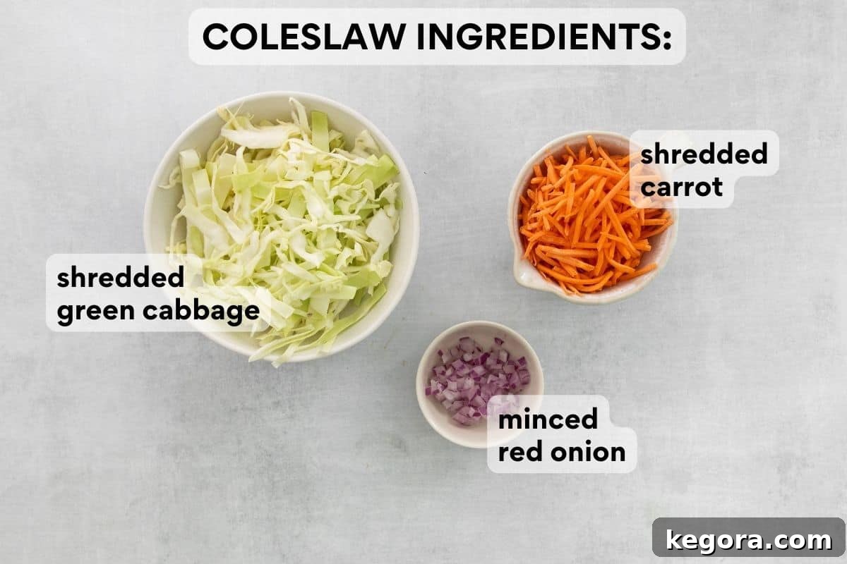 Pre-measured green cabbage, minced onion, and shredded carrots in separate bowls, ready for the dairy-free coleslaw.