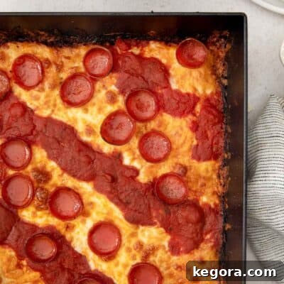up close of Detroit-style pizza in pizza pan.