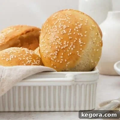 A single perfectly baked gluten-free hamburger bun, turned upright, showcasing its golden crust and round shape.