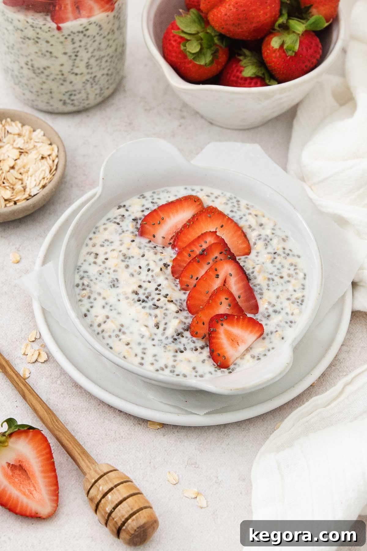 Protein Chia Oats with Strawberry Topping A bowl of creamy overnight protein chia oats topped with fresh strawberry slices arranged in a neat line, ready to be enjoyed.