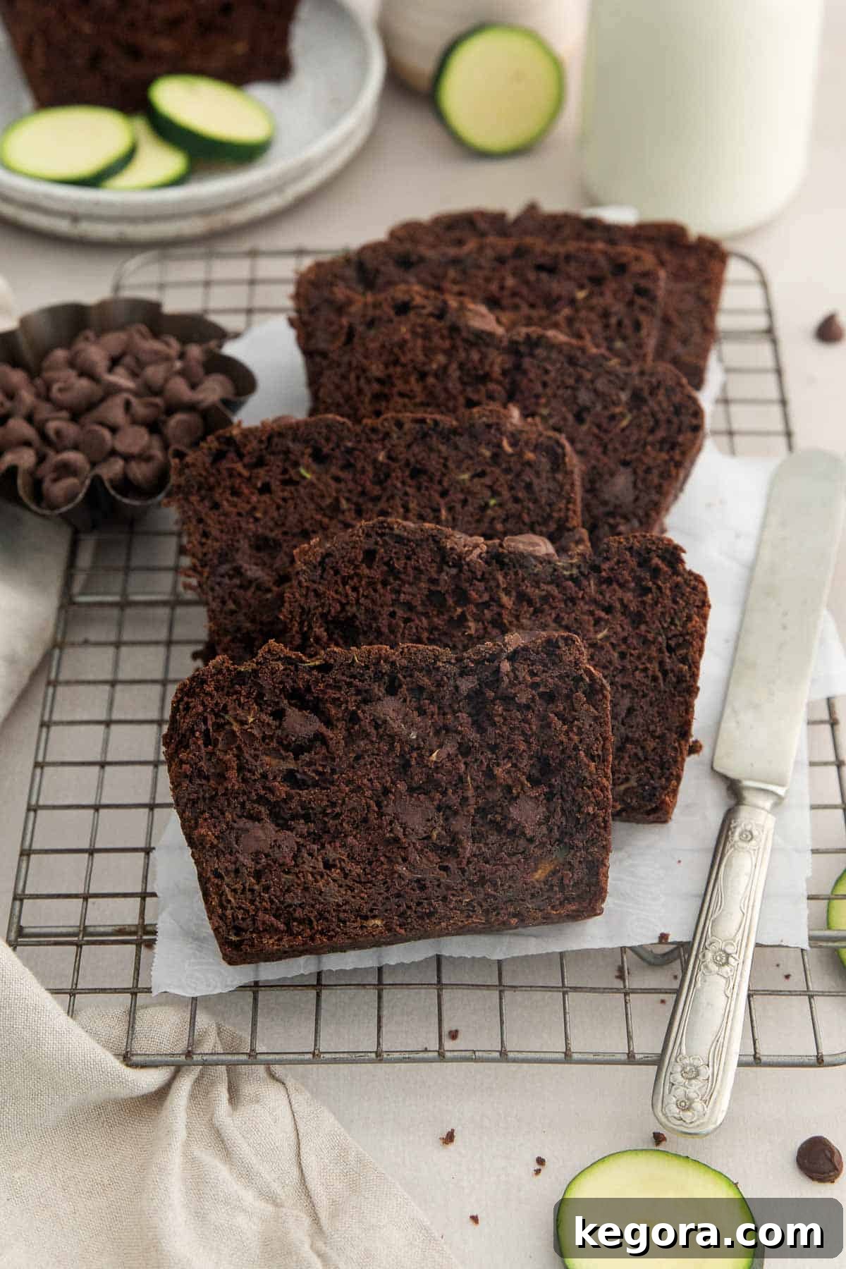 The Ultimate Gluten-Free Double Chocolate Zucchini Bread 3 Artfully arranged slices of rich double chocolate zucchini bread on a rustic wire cooling rack, highlighting its moist texture and chocolate chips.