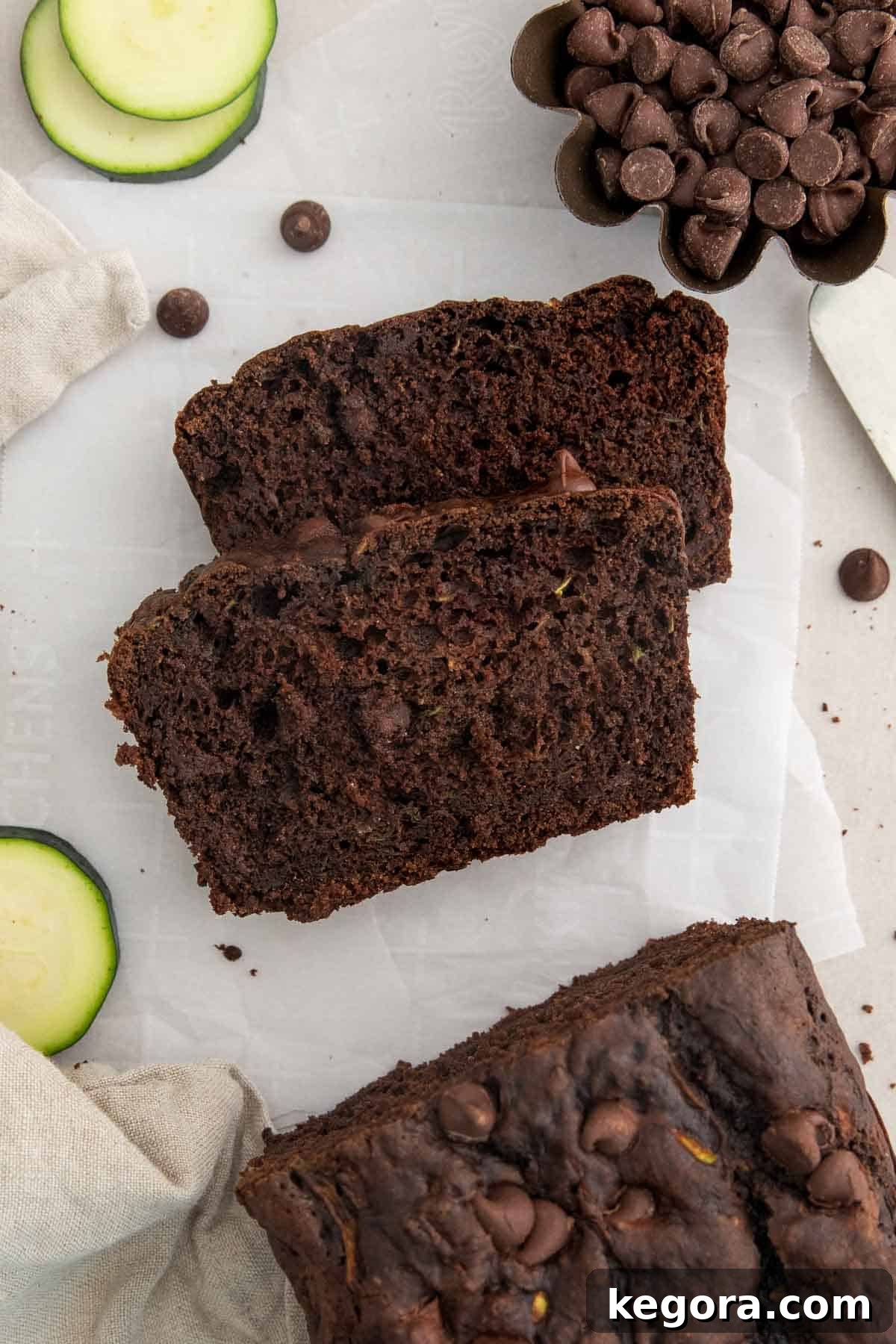 The Ultimate Gluten-Free Double Chocolate Zucchini Bread 6 Two perfectly cut slices of rich double chocolate zucchini bread showcased next to the freshly baked loaf on a wooden board, ready for serving.