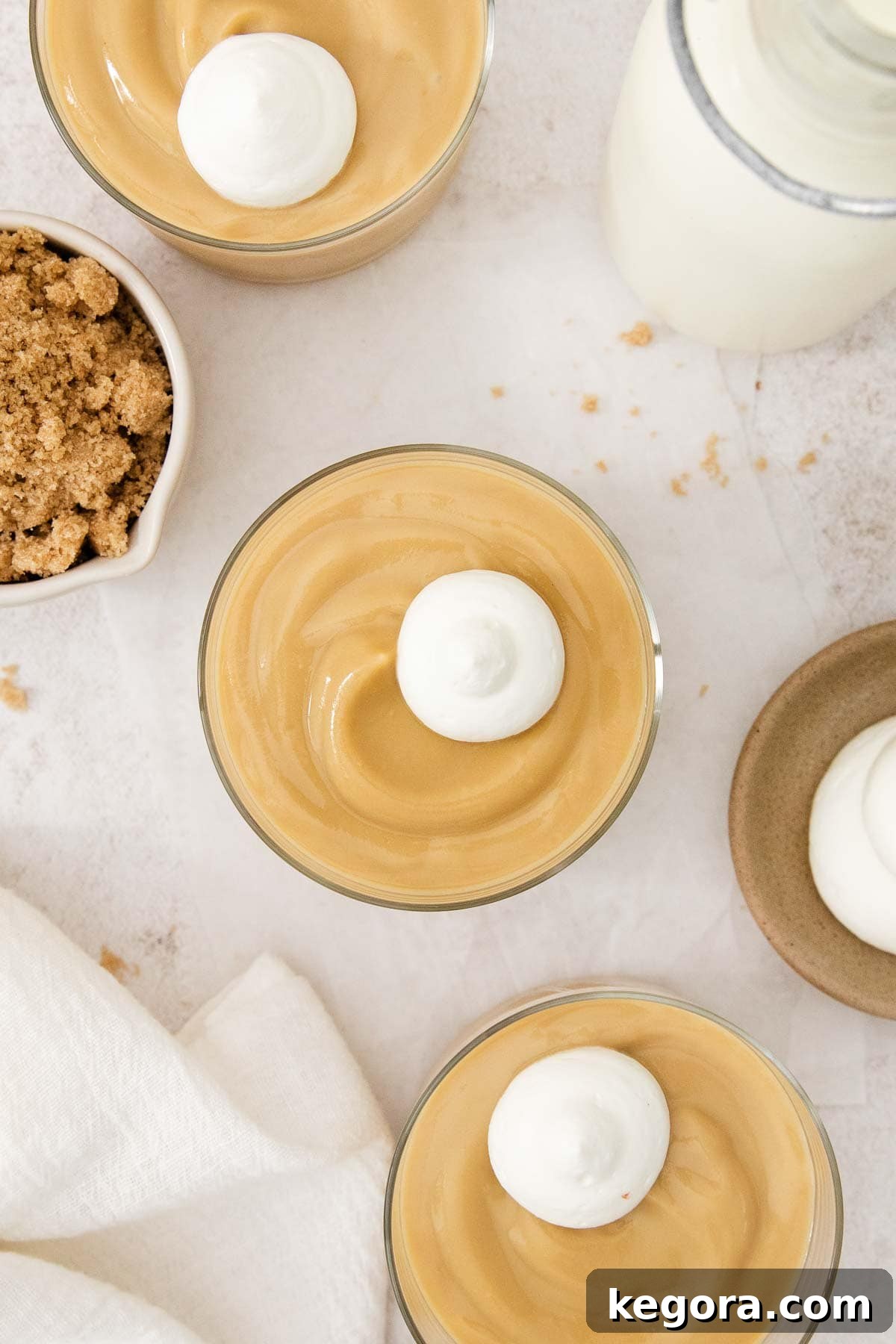 The Finest Butterscotch Pudding 8 Beautifully presented butterscotch pudding in individual glass dishes, generously topped with whipped cream, ready for serving.