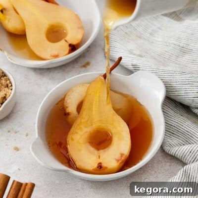 Perfectly poached apple cider pears, showcasing their tender texture and rich syrup.