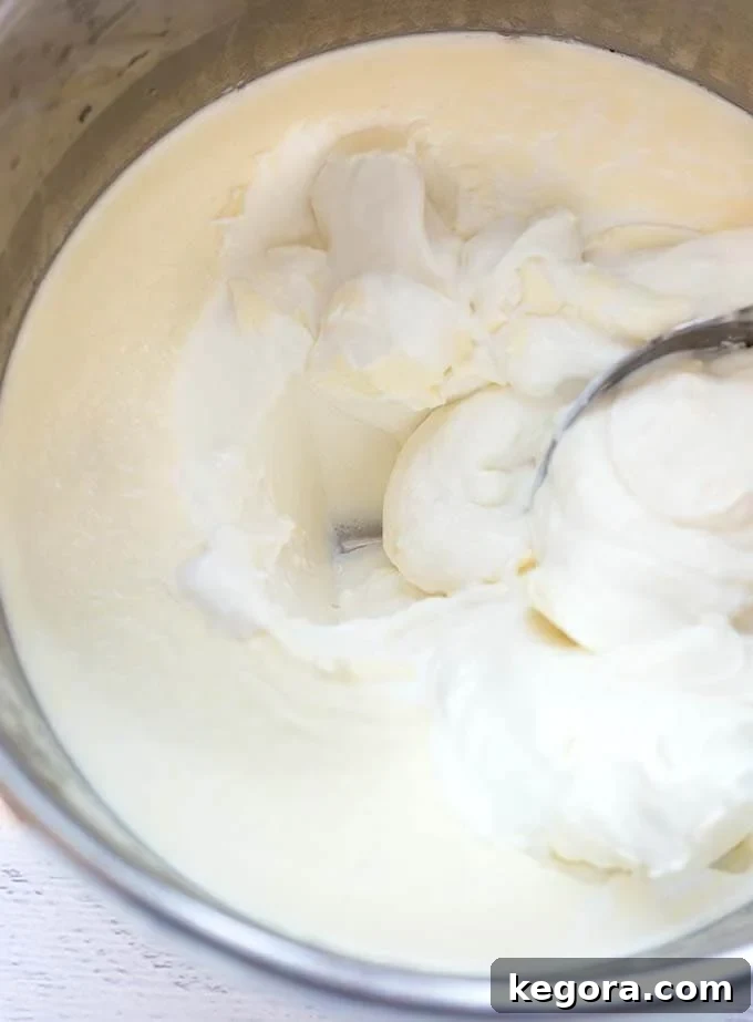 Effortless Instant Pot Yogurt 4 Spoon scooping yogurt directly from the pressure cooker pot, highlighting the ease of preparation.