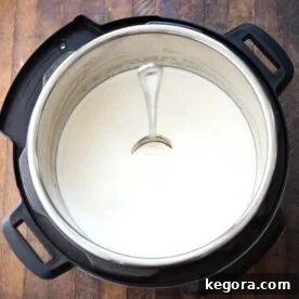 Effortless Instant Pot Yogurt 8 Yogurt in pressure cooker with spoon standing straight in yogurt