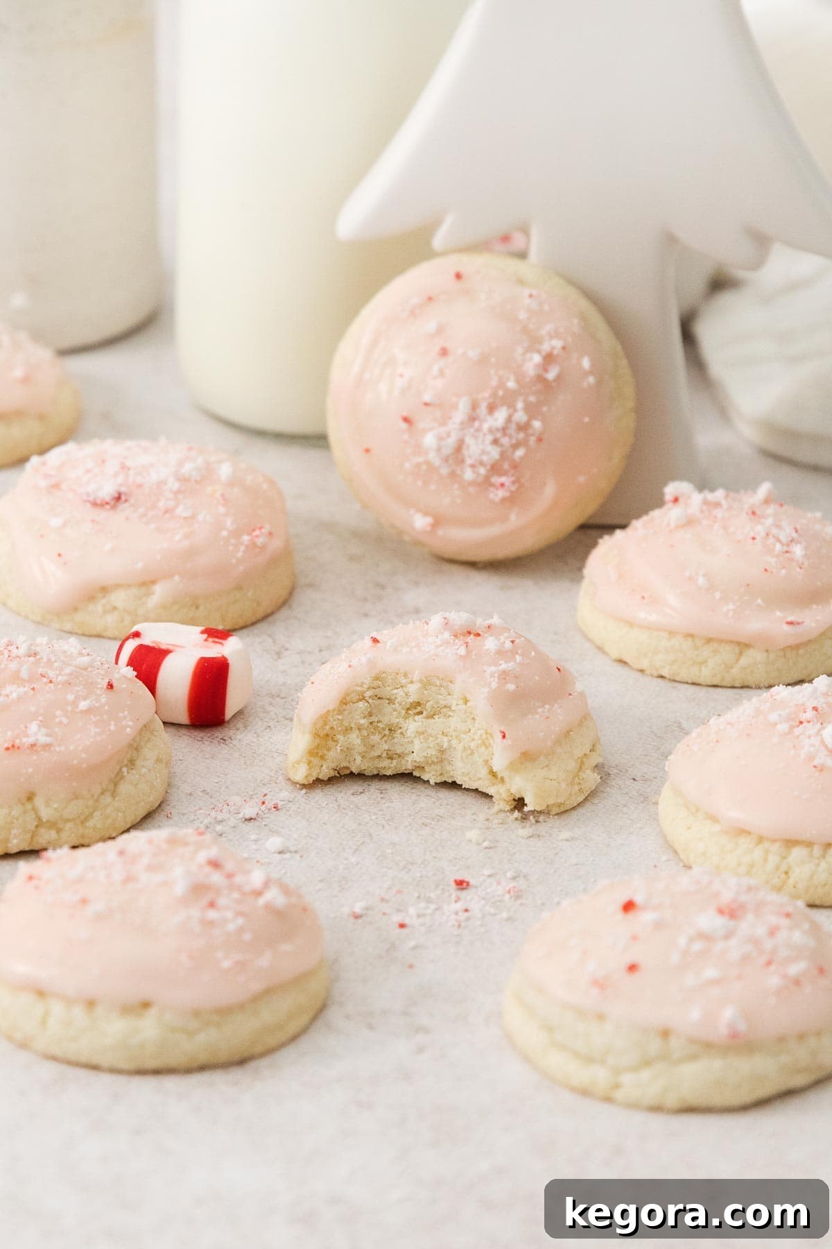 Velvet Gluten-Free Peppermint Melts 7 Two peppermint meltaways, one with a bite taken out, sitting on a wooden surface.