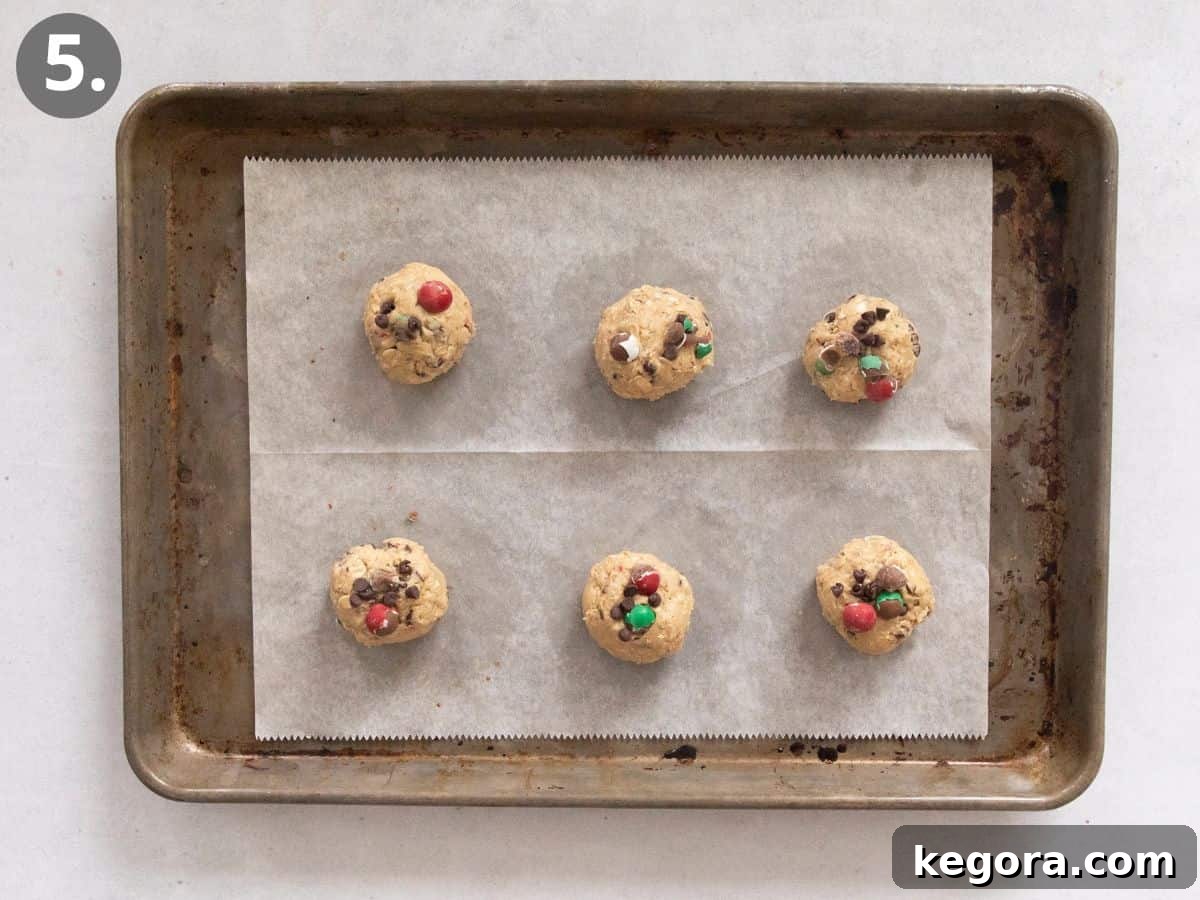 A baking sheet filled with perfectly shaped Cadbury Snowball cookie dough balls, evenly spaced and ready for the oven, hinting at the delicious treats to come.