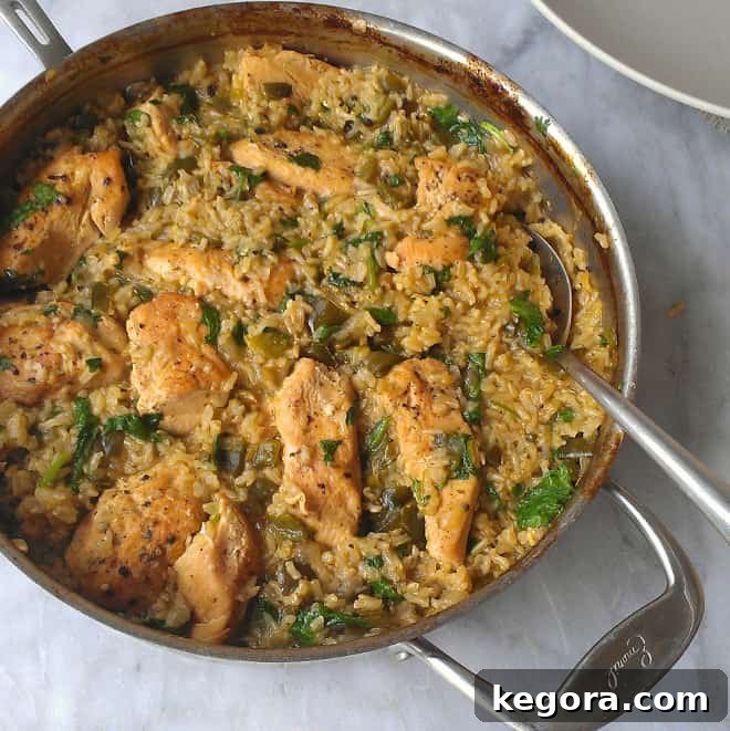 A skillet filled with succulent chicken and vibrant green Mexican rice, garnished with fresh herbs, offering a complete and flavorful gluten-free meal.