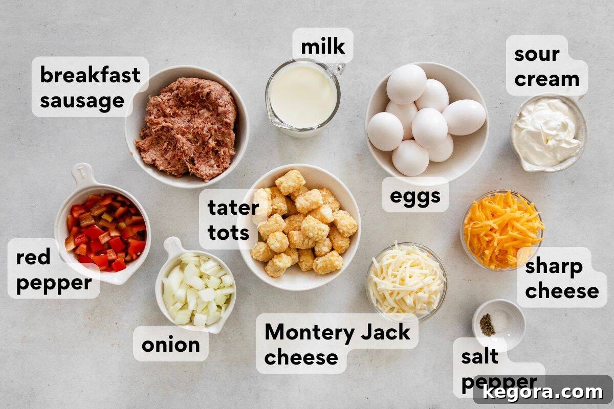 Carefully measured and labeled ingredients for gluten-free tater tot breakfast casserole, including tater tots, breakfast sausage, eggs, milk, sour cream, diced peppers, onions, and various cheeses.