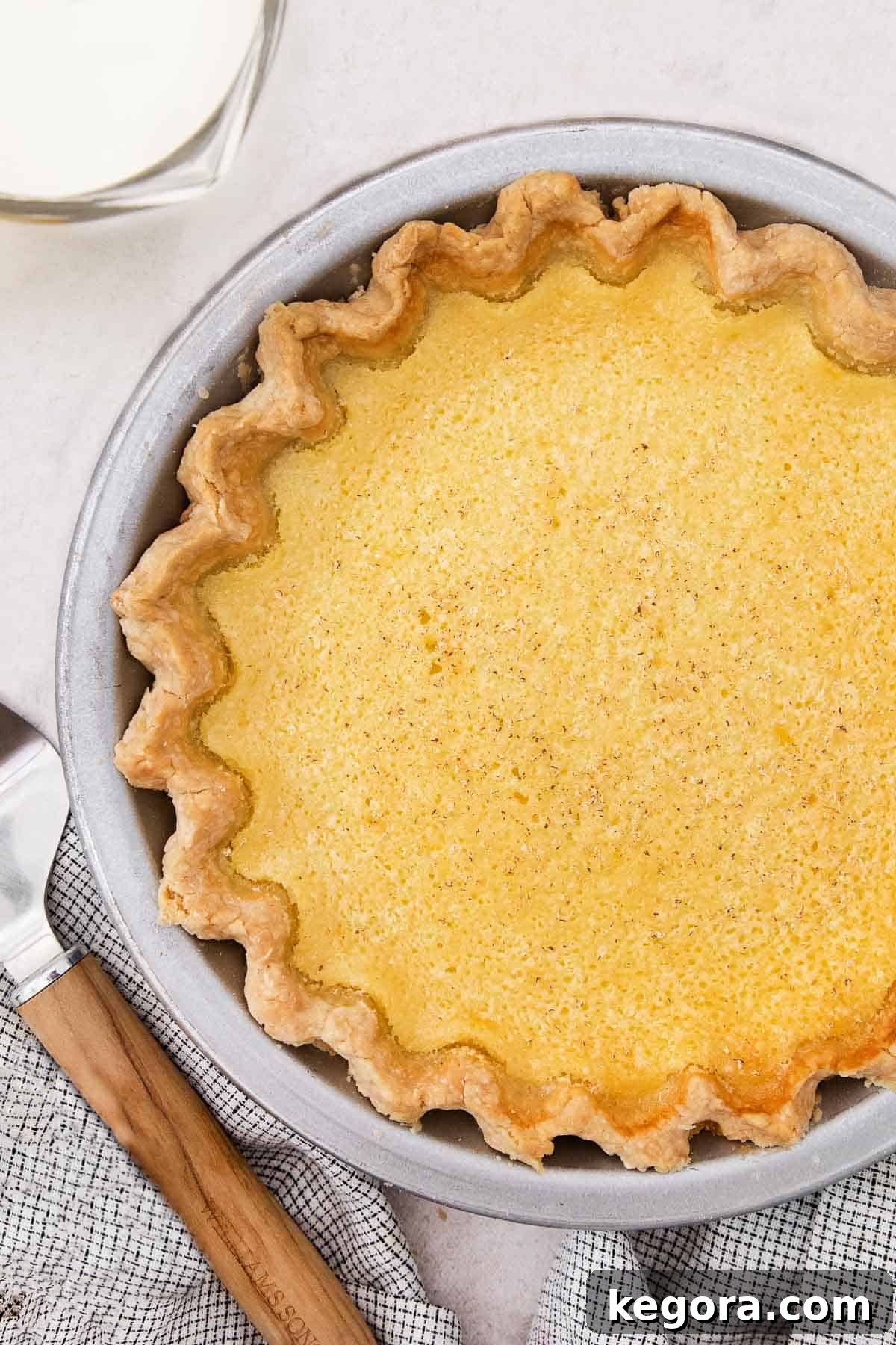 Southern Charm Gluten-Free Buttermilk Pie 3 A delicious whole gluten-free buttermilk pie in a metal pie plate, ready to be sliced and served.