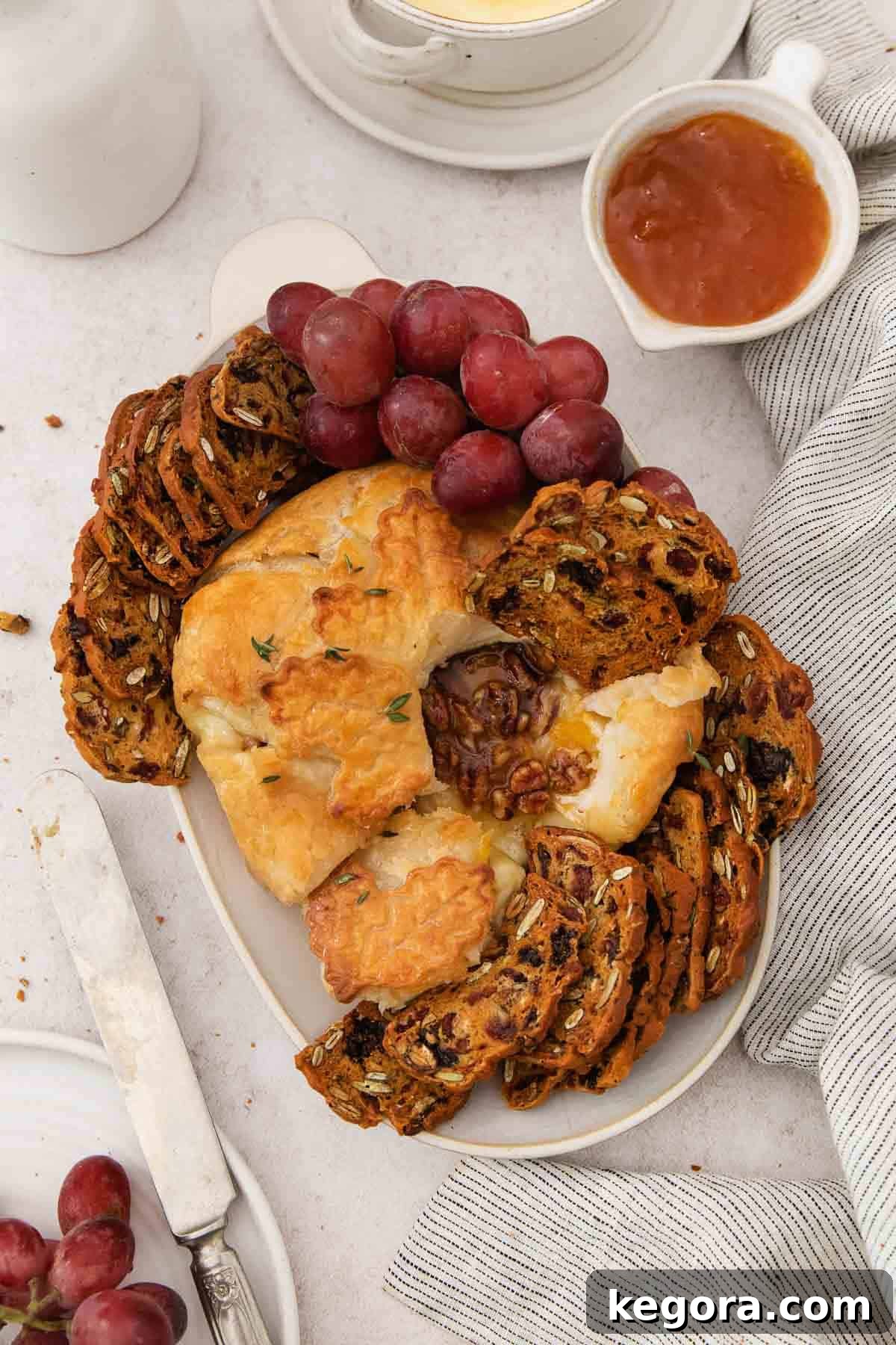Decadent Gluten-Free Warm Brie 4 Gluten-free baked brie on a platter with gluten-free crackers and grapes.