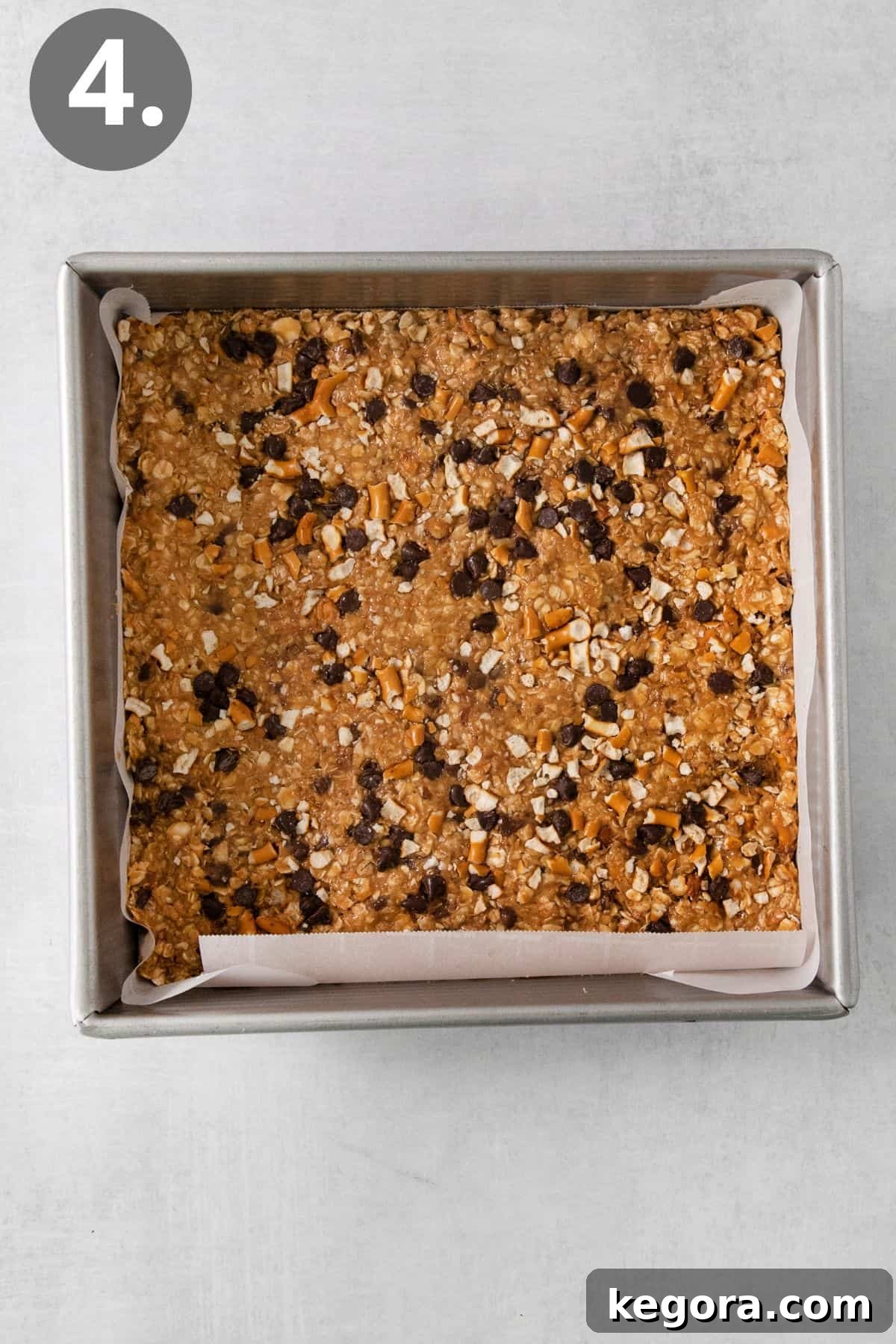 The peanut butter oatmeal bar mixture evenly pressed into a parchment-lined baking dish.