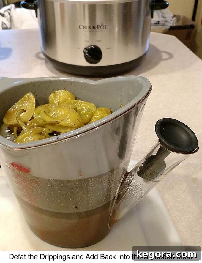 Ultimate Mississippi Slow Cooker Roast 5 Defatted drippings collected in a fat separator, showing the clear, flavorful liquid below the separated fat.