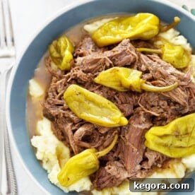 Ultimate Mississippi Slow Cooker Roast 7 Mississippi Pot Roast in a blue bowl next to a fork