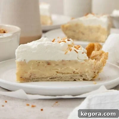 a slice of coconut cream pie on a white plate.