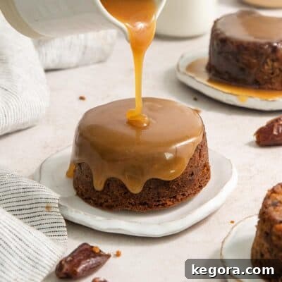 Gluten-free sticky toffee pudding on a plate with sauce being poured over the top