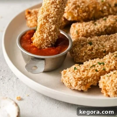 A plate of gluten-free mozzarella sticks and a bowl of marinara sauce