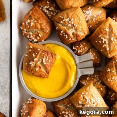 a close-up photo of gluten-free soft pretzel bites with cheese dip