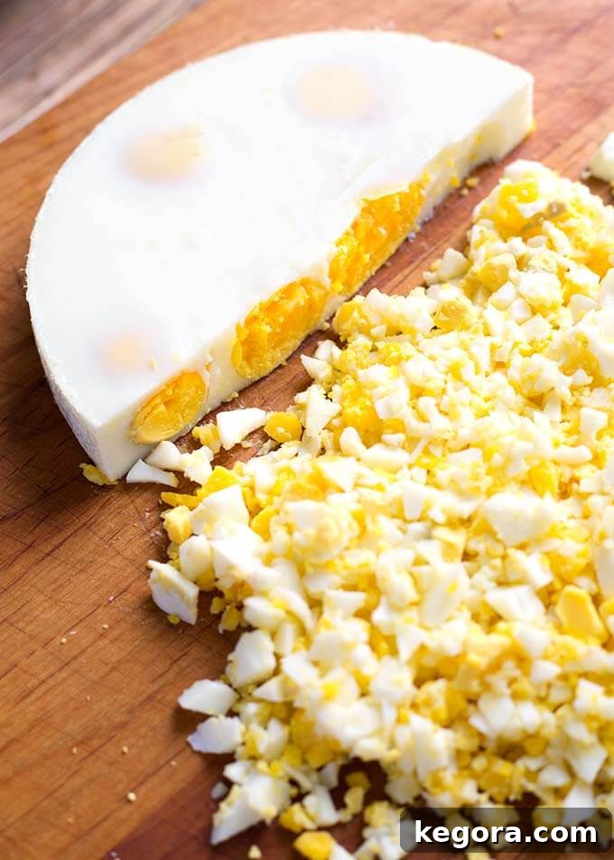 Egg Loaf on a wooden cutting board with half of loaf crumbled, ready to be used in recipes