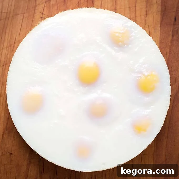 Go-To Instant Pot Egg Loaf 5 Top view of a whole, perfectly formed egg loaf on a wooden board, ready for slicing or chopping