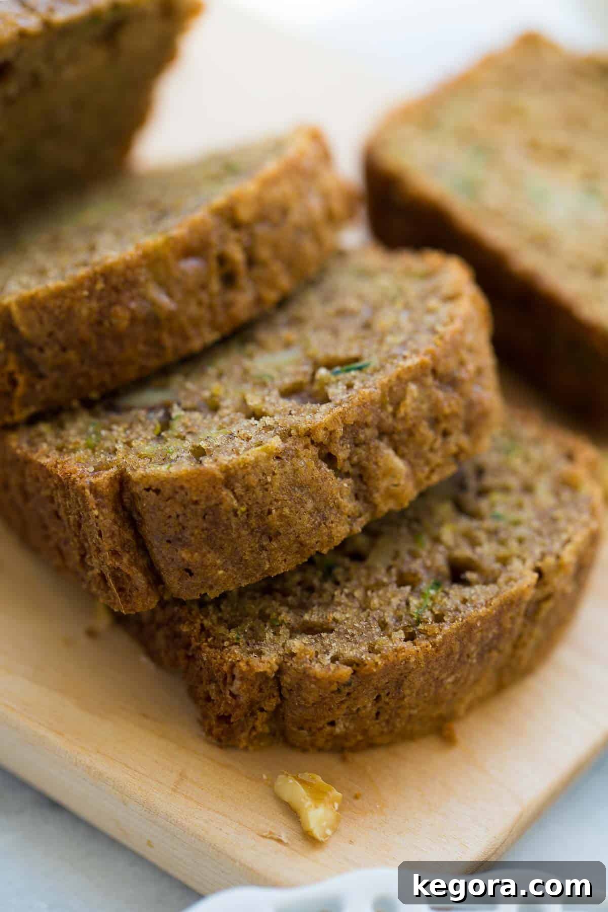 Guilt-Free Zucchini Bread 2 Slices of moist gluten-free zucchini bread on a rustic wooden countertop, ready to be enjoyed.