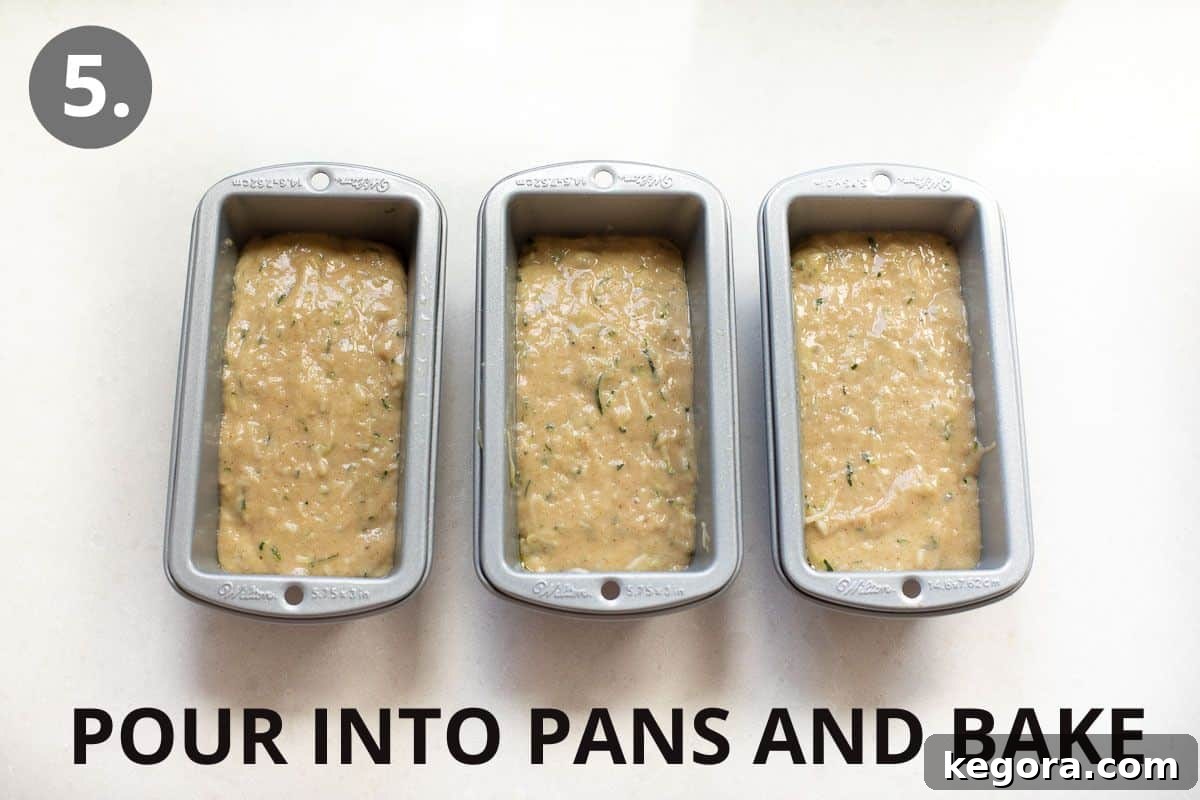 Guilt-Free Zucchini Bread 8 Three mini loaf pans filled with golden-brown zucchini bread batter, ready for baking.