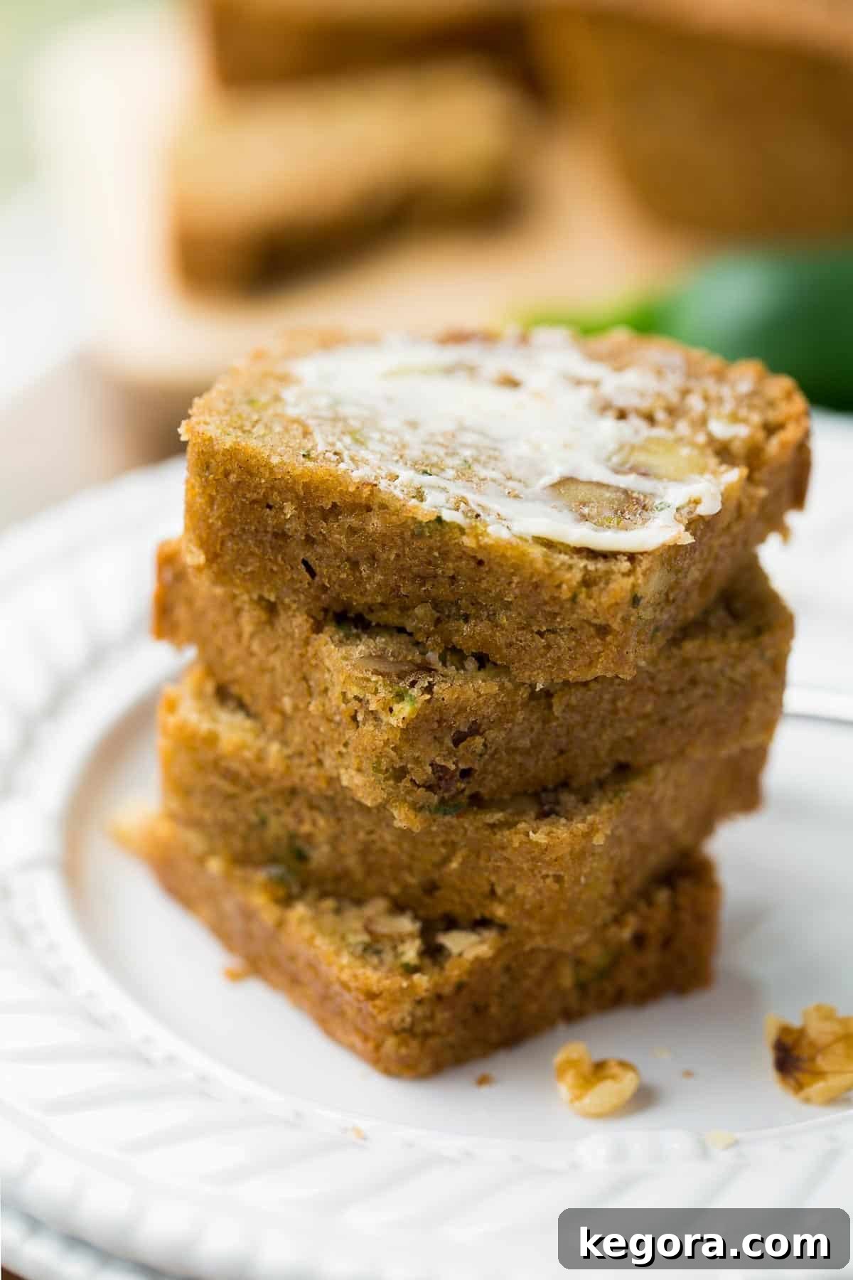 Guilt-Free Zucchini Bread 9 Several slices of moist gluten-free zucchini bread stacked, with one slice generously spread with butter.