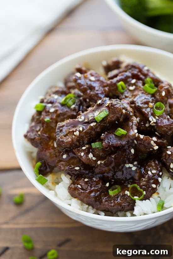 Homemade Beef Teriyaki Recipe Beef Teriyaki in a bowl on a bed of white rice, garnished with sesame seeds and green onions