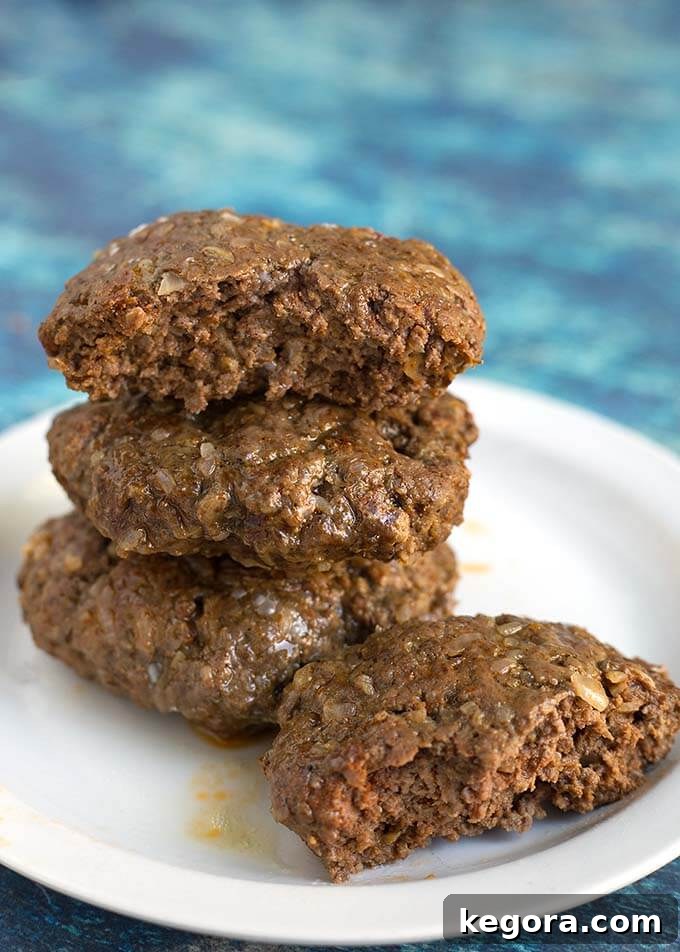 Unlock Juicy Burgers with Your Instant Pot 5 Three Hamburgers patties stacked on a white plate with half a hamburger patty next to them