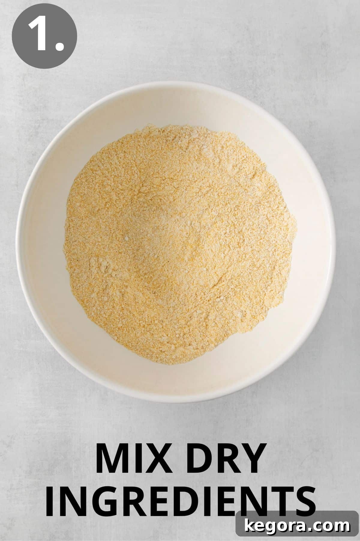 Silky Corn Cakes 5 Dry ingredients for cornmeal pancakes, including cornmeal, gluten-free flour, sugar, baking powder, baking soda, and salt, are stirred together in a large mixing bowl.