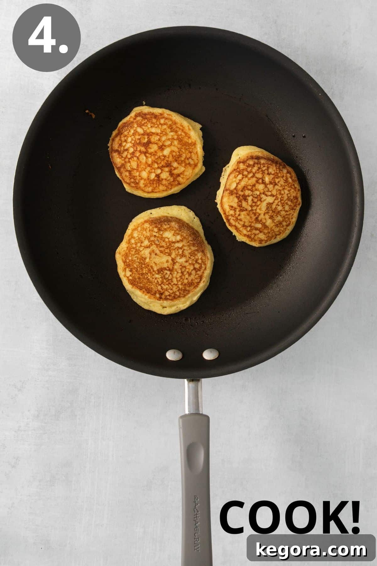 Silky Corn Cakes 8 Small, round cornmeal pancakes sizzling and browning on a hot non-stick skillet or griddle, showing bubbles forming on the surface.