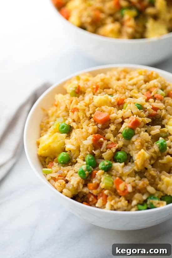 50/50 Cauliflower and Brown Rice Fried Rice Gluten Free 3 A close-up shot of 50/50 Cauli-Brown Rice Fried Rice, showcasing the blend of brown rice and cauliflower rice with colorful vegetables and scrambled eggs.