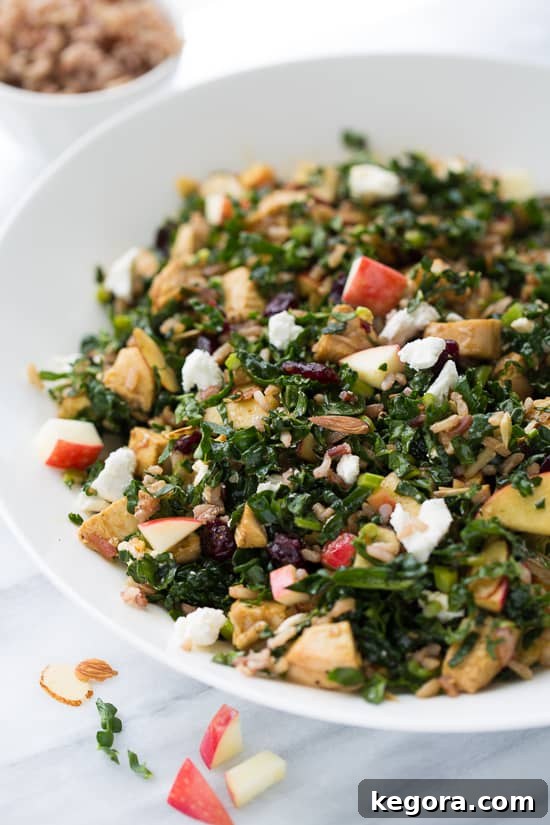 Nutrient-packed Chicken Kale and Wild Rice Salad with cranberries, almonds, apples, and goat cheese - a healthy and satisfying copycat recipe.