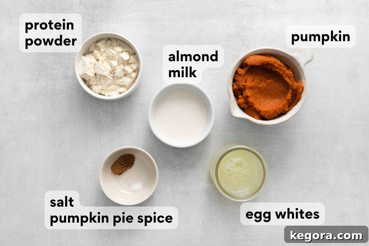 All the measured ingredients for pumpkin protein pancakes laid out on a table.