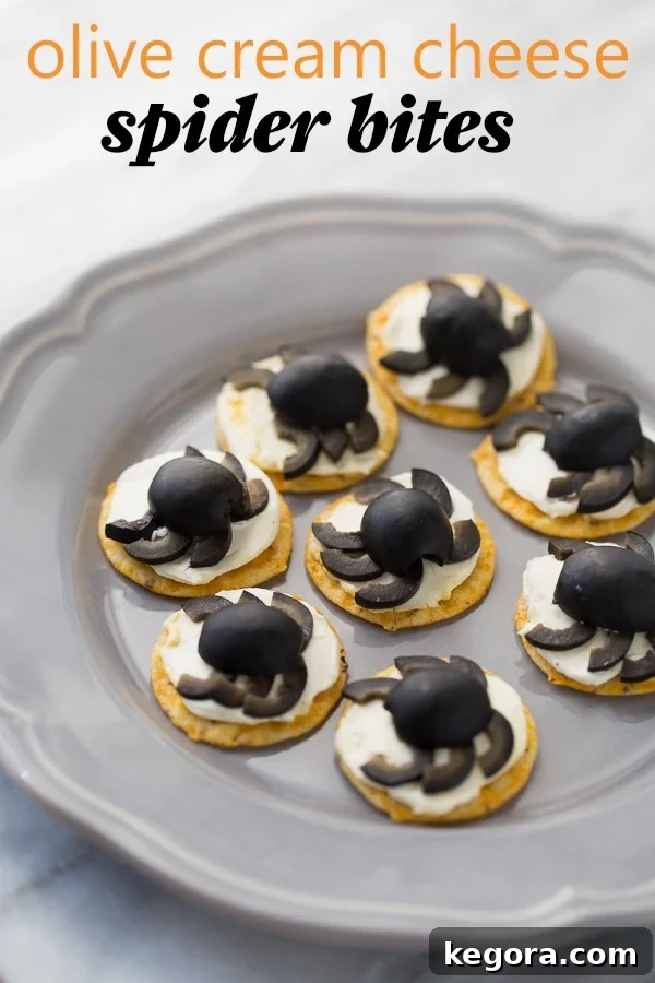 Spooktacularly Healthy Treats 3 Delicious Olive Cream Cheese Spider Crackers arranged on a gray plate against a elegant marble background.