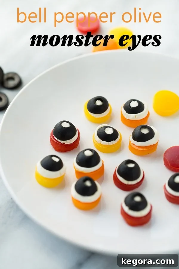 Spooktacularly Healthy Treats 4 Creepy Bell Pepper Olive Monster Eyes served on a white plate against a stylish marble background.